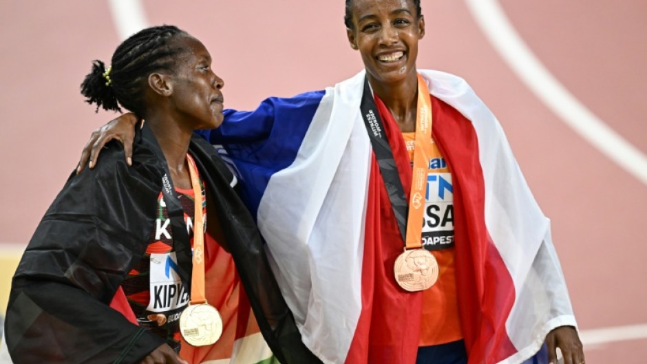 Sifan Hassan (R) stands with Faith Kipyegon