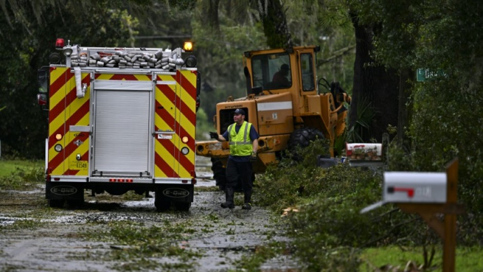 A first responder clears debris off the street in Perry, Florida after Hurricane Idalia slammed into the coast as a powerful Category 3 storm on August 30, 2023