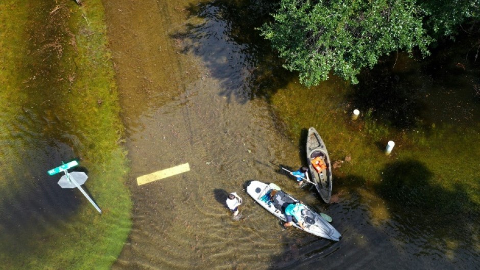 People prepare to kayak through the flooded streets of Crystal River, Florida, amid flooding caused by Hurricane Idalia