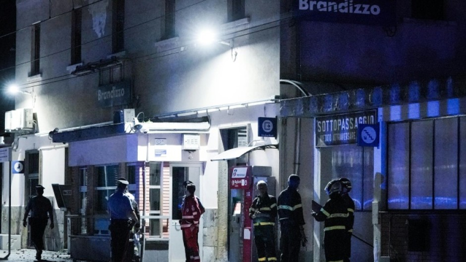 Firefighters and police officers at the train station in Brandizzo, Italy, where the maintenance workers were hit