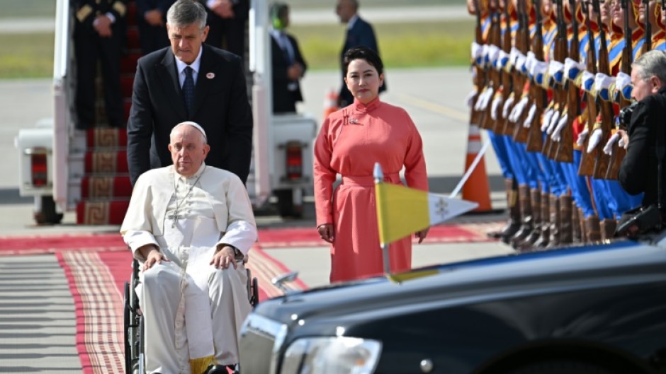 Pope Francis is received by Mongolia's Minister of Foreign Affairs Batmunkh Battsetseg (R, in red) during his arrival at Chinggis Khaan International Airport in Ulaanbaatar on September 1, 2023. 