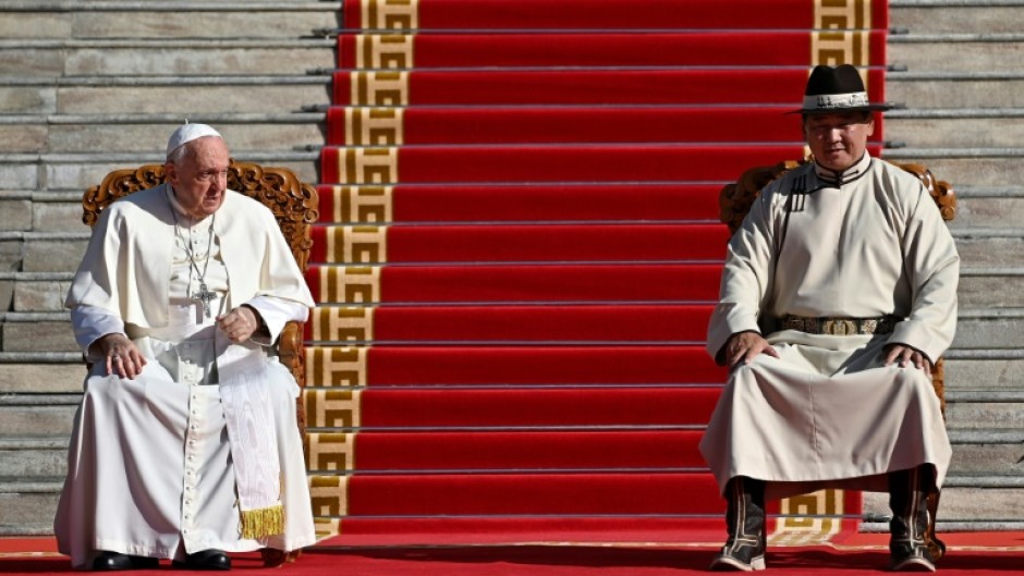Mongolian President Ukhnaa Khurelsukh (R) receives Pope Francis during a welcome ceremony at Sukhbaatar Square in Ulaanbaatar