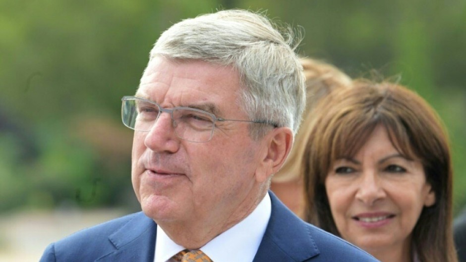 IOC president Thomas Bach (L) and Paris Mayor Anne Hidalgo on the quays of the Seine River in Paris on July 25, 2023