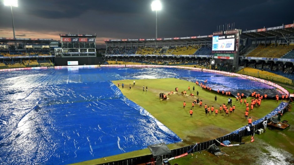 Rain pain: Ground staff cover the pitch after rain stopped play during the Asia Cup match between India and Pakistan 
