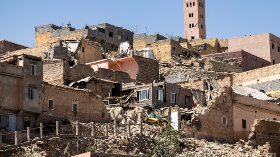 The minaret of a mosque stands behind destroyed houses in Moulay Brahim, Al-Haouz province