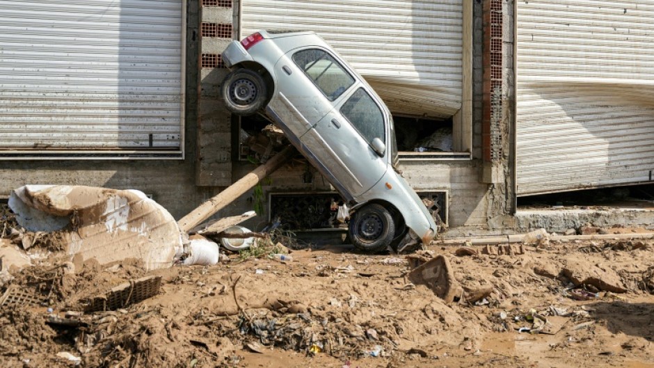 A car swept up against the side of a Benghazi building by the floodwaters