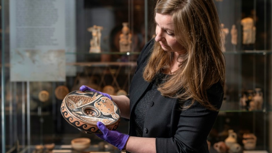 Museum curator Georgia Pike-Rowney with the red fish plate traced to American art trafficker  David Holland Swingler