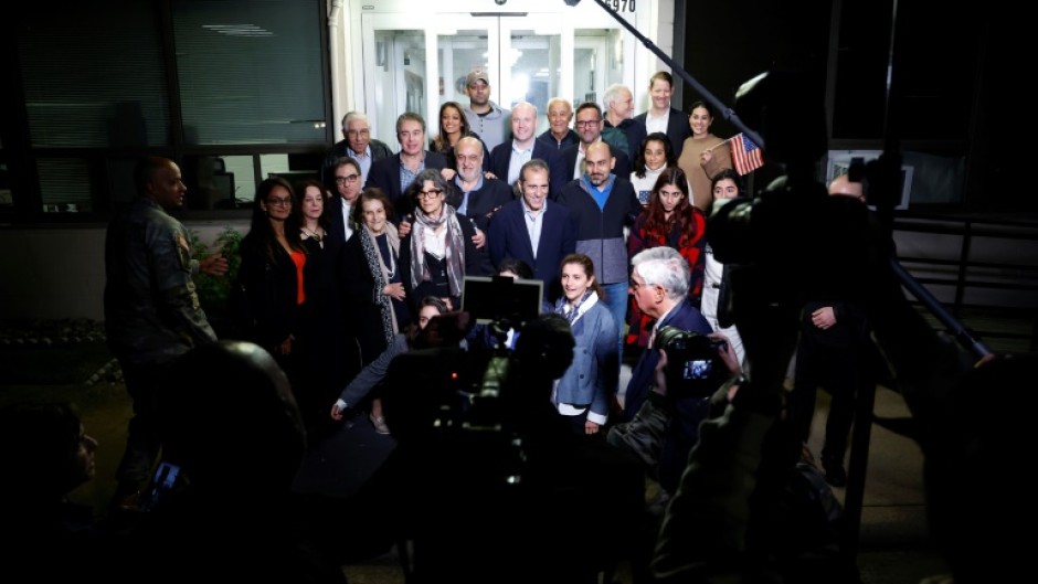 US officials arrange a group photo of the former prisoners freed by Iran landed at an airfield near Washington 