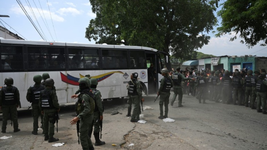 Inmates board a bus as they are transferred from the prison