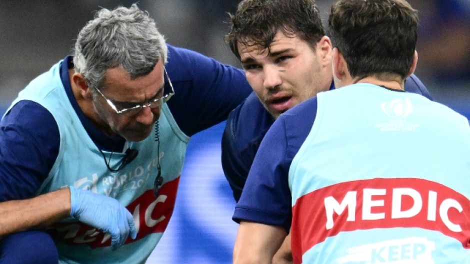 France's scrum-half and captain Antoine Dupont (C) receives medical attention during France's match against Namibia