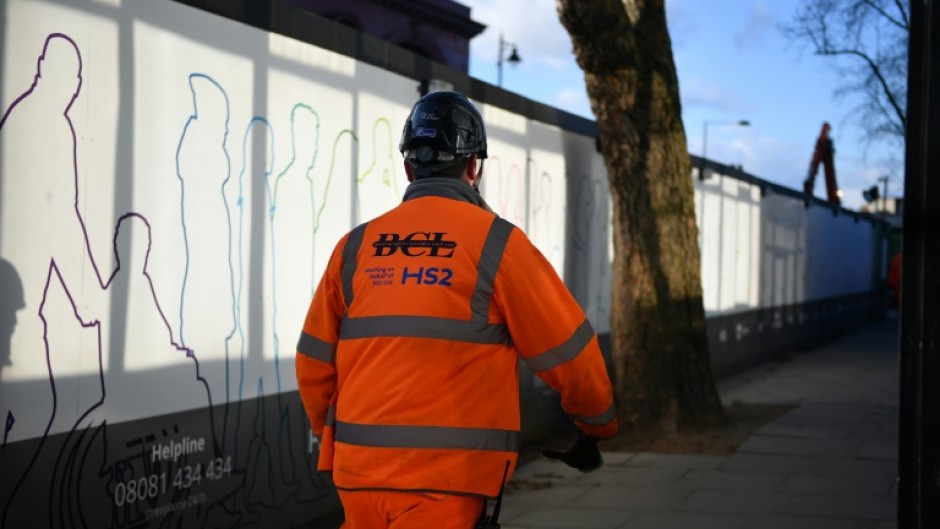 A construction worker walks outside a construction site for a section of Britain's HS2 high-speed railway project at London Euston train station 