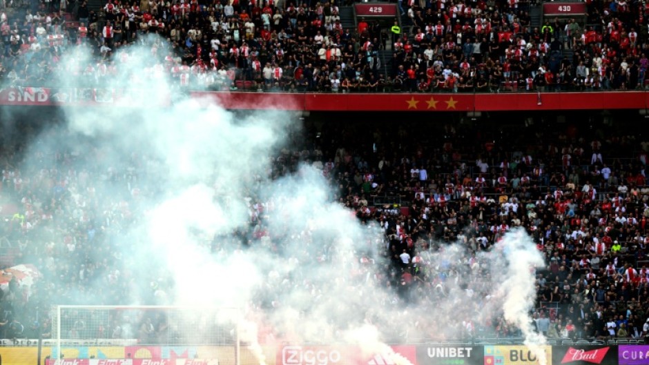 Smoked out: Flares are thrown onto the pitch as the game between Ajax and Feyenoord was abandoned
