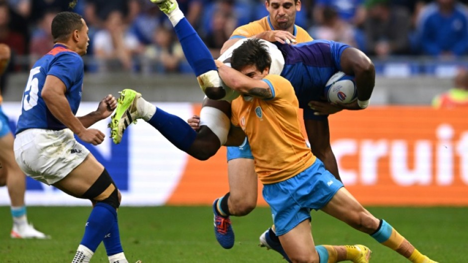 Namibia's openside flanker and captain Tjiuee Uanivi is tackled by Uruguay's scrum-half Santiago Arata during the teams Rugby World Cup clash in Lyon