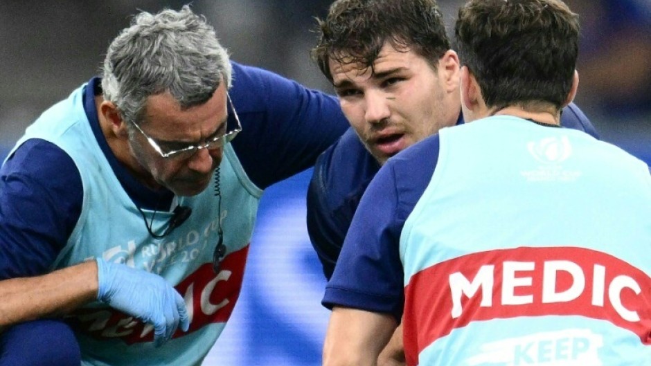 France captain Antoine Dupont (C) receives medical attention