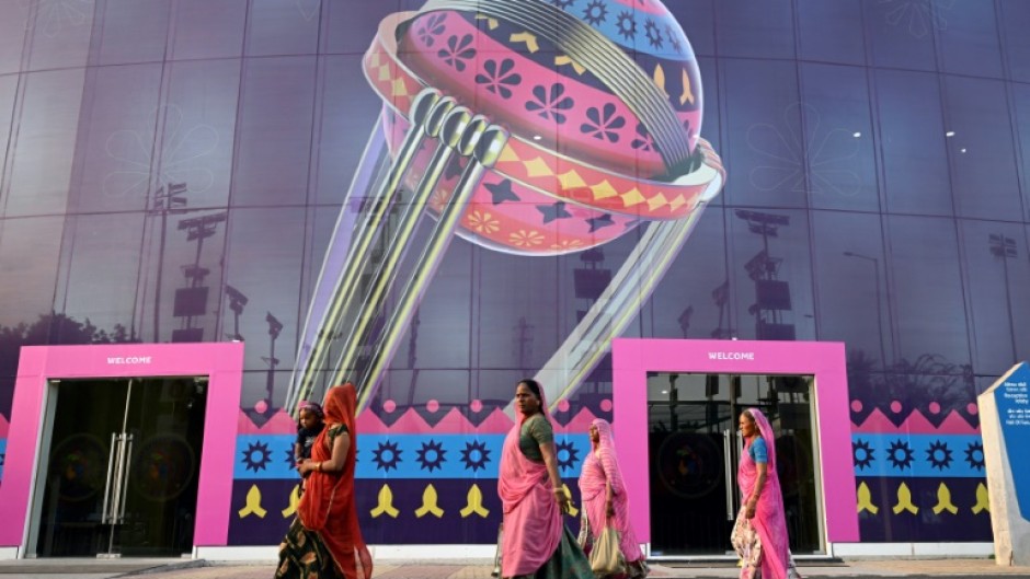 'Cricket crazy': Women along with a child walk inside the complex of the Narendra Modi Stadium 