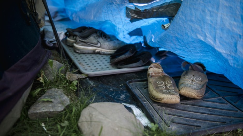 Shoes belonging to a woman are left just outside her tent in a makeshift homeless encampment in a park in Granby, Canada