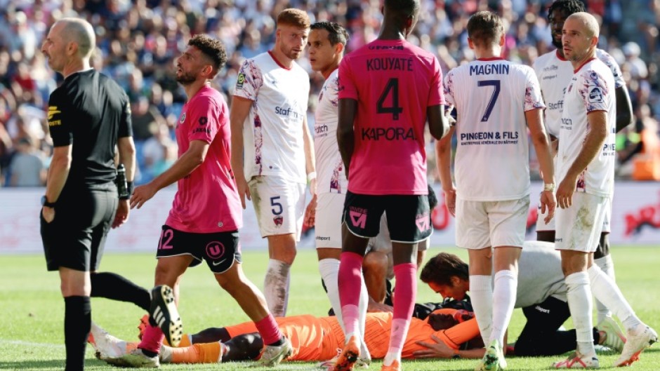 Clermont goalkeeper Mory Diaw (C) lies on the ground after a firecracker exploded next to him during his side's Ligue 1 game at Montpellier