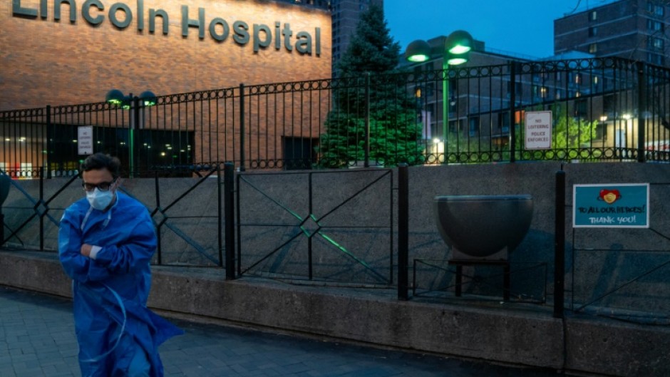 A member of the medical staff walks by a sign thanking medical workers at Lincoln Hospital in April 2020; While the initial public reaction to the pandemic was to honor health workers, they later found themselves on the frontlines of public frustration