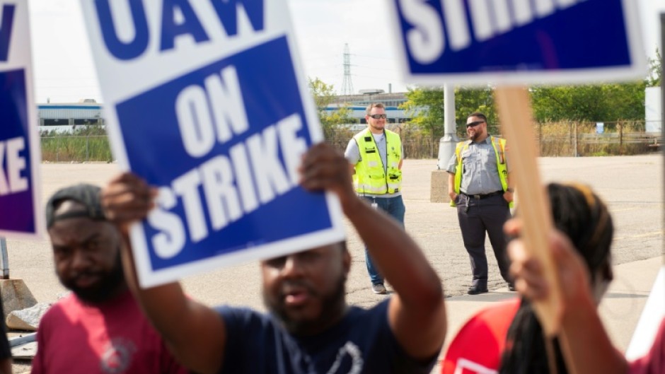 UAW members and workers at Mopar Parts Center Line, a Stellantis parts distribution center in Center Line, Michigan, hold signs after walking off their jobs on September 22, 2023 