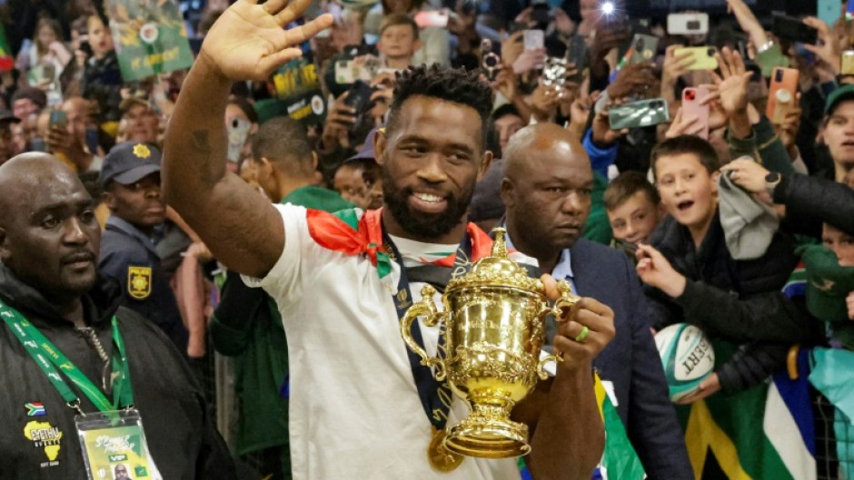 South Africa captain Siya Kolisi waves to supporters at Johannesburg airport while holding the Rugby World Cup trophy

