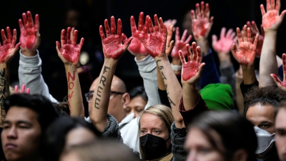 Protestors calling for a ceasefire in Gaza raise red-painted hands during a US Senate hearing in Washington, DC on October 31, 2023