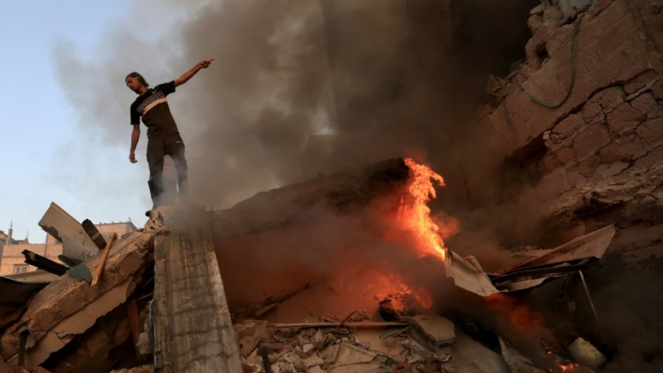 A Palestinian on the rubble of a collapsed building following an Israeli strike on Khan Yunis in south Gaza