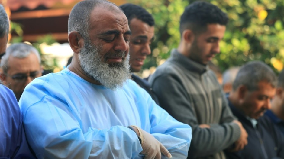 Palestinian men pray for war victims in Khan Yunis in the southern Gaza Strip on November 9, 2023