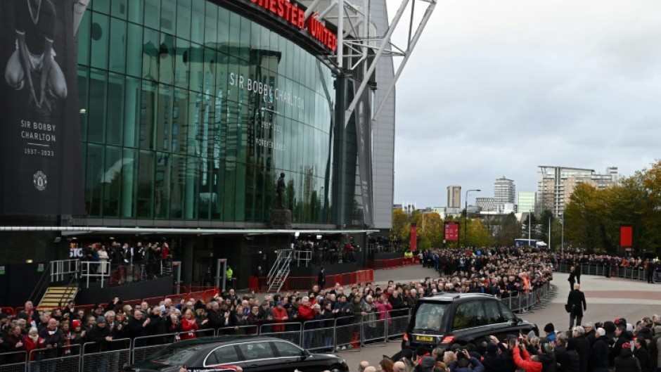 A hearse carrying the coffin of Bobby Charlton is driven past Old Trafford