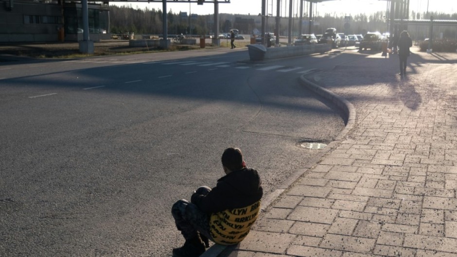 One of the final asylum seekers at the Nuijamaa border crossing between Finland and Russia waits before the crossing is closed -- one of four that Finland will shut at midnight over a surge in undocumented migrants