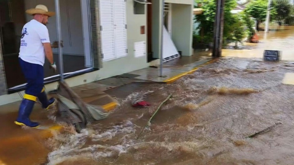 Residents in the town of Roca Sales clean flooded streets on November 19, 2023 after heavy rains hit southern Brazil leaving at least six dead, according to authorities