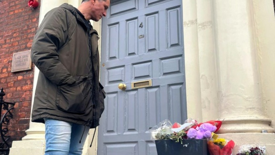 Brazilian Caio Benicio looks at flowers placed at the scene of the November 23 attack in Dublin