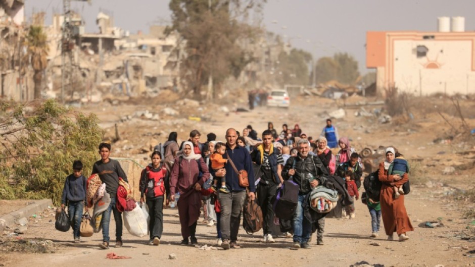 Palestinians fleeing the north walk along Salaheddine road in Zeitoun district on the outskirts of Gaza City