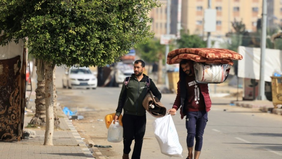Residents of the Qatari-funded Hamad Town residential complex in Khan Yunis flee with their belongings after receiving notification from the Israeli army of an imminent strike