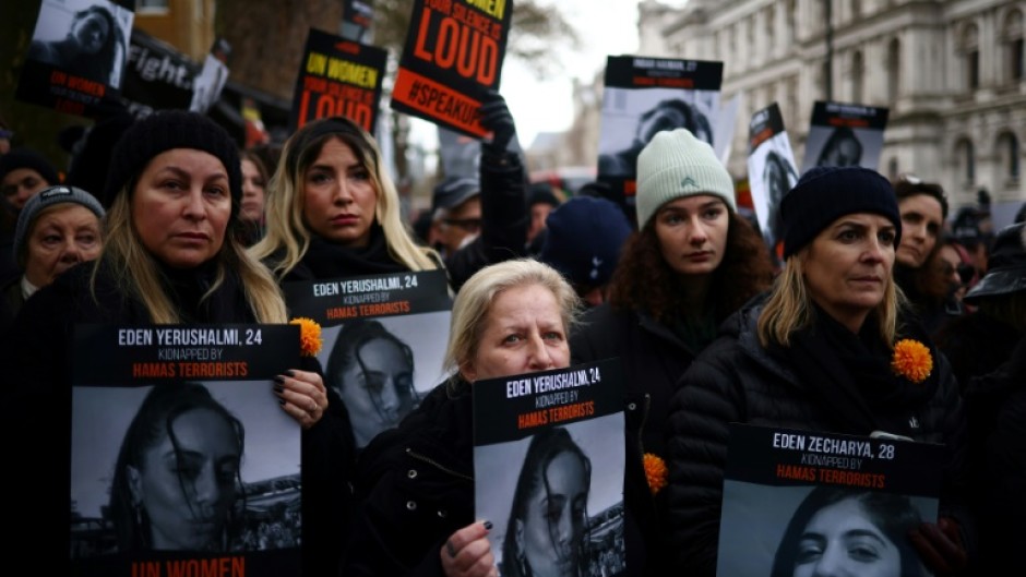 Demonstrators hold posters reading 'UN Women, your silence is loud' alongside pictures of Israeli women being held hostage in Gaza, during a rally in London on December 3, 2023 