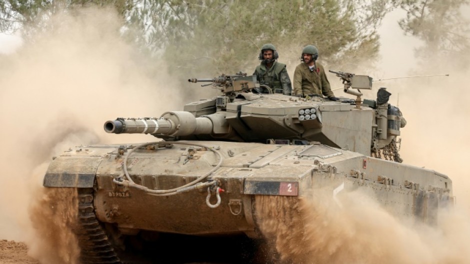 An Israeli tank rolls near the border with the Gaza Strip on December 5, 2023