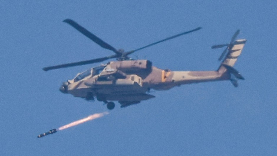 An Israeli air force attack helicopter fires a missile while flying in an area along the border with the Gaza Strip and southern Israel on December 12, 2023 