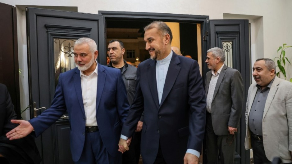 Qatar-based Hamas leader Ismail Haniyeh (L) welcomes Iranian Foreign Minister Hossein Amir Abdollahian (C), in Doha