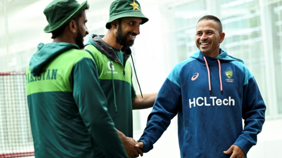 Australia's Usman Khawaja (R) shares a joke with Pakistan's Hasan Ali (L) and Shan Masood (C) at the Melbourne Cricket Ground
