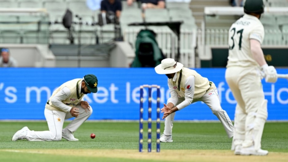 Pakistan's Abdullah Shafique (L) drops a catch from Australian batsman David Warner (R)