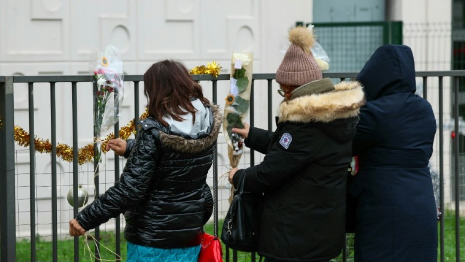 People tied flowers to the railing outside the family's flat on Tuesday