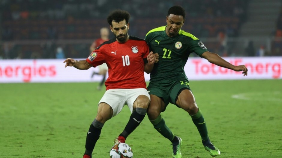 Egypt captain Mohamed Salah (L) fights for the ball  with Senegal forward Mame Thiam during the 2022 Africa Cup of Nations final in Yaounde.
