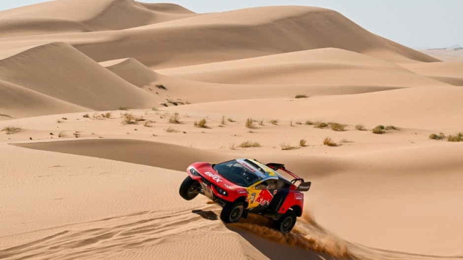 Heading for the rocks: Sebastien Loeb races through the dunes on stage 3 before suffering a series of punctures