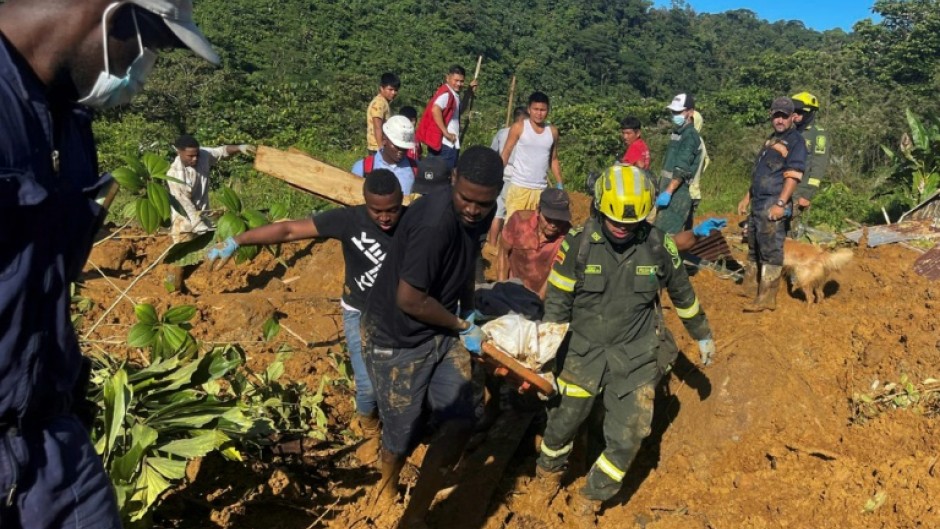 Rescue teams carry a corpse from the area of a landslide in Choco Department, Colombia