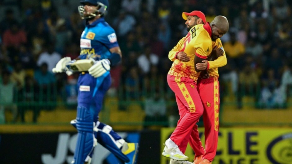 Zimbabwe's Luke Jongwe celebrates with Sikandar Raza (R) after taking the wicket of Sri Lanka's Kusal Mendis (L) during the second T20 between Sri Lanka and Zimbabwe