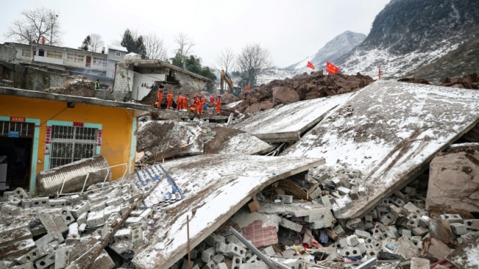Rescue workers search for missing victims at a landslide site, a day after it hit Liangshui village in southwestern China's Yunnan province