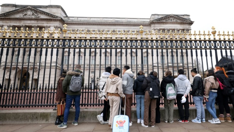 Tourists gathered outside Buckingham Palace following news of King Charles's cancer diagnosis
