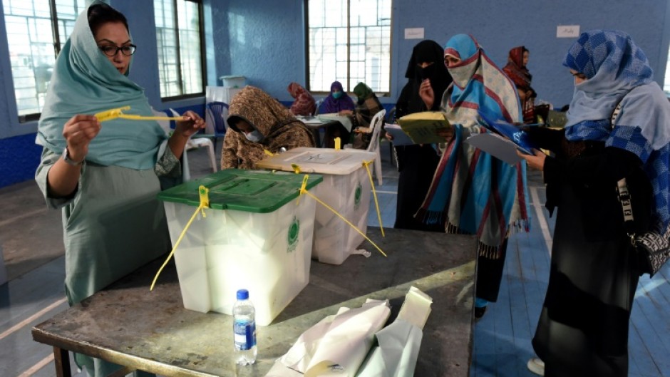 Pakistan election workers open ballot boxes as they begin counting votes in the country's national election