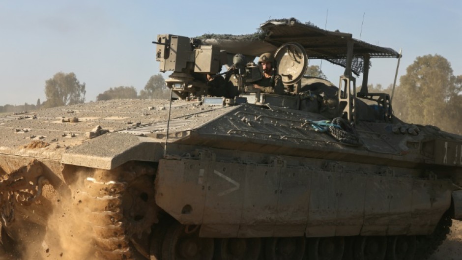 An Israeli military armoured vehicle rolls near the border with the Gaza Strip 