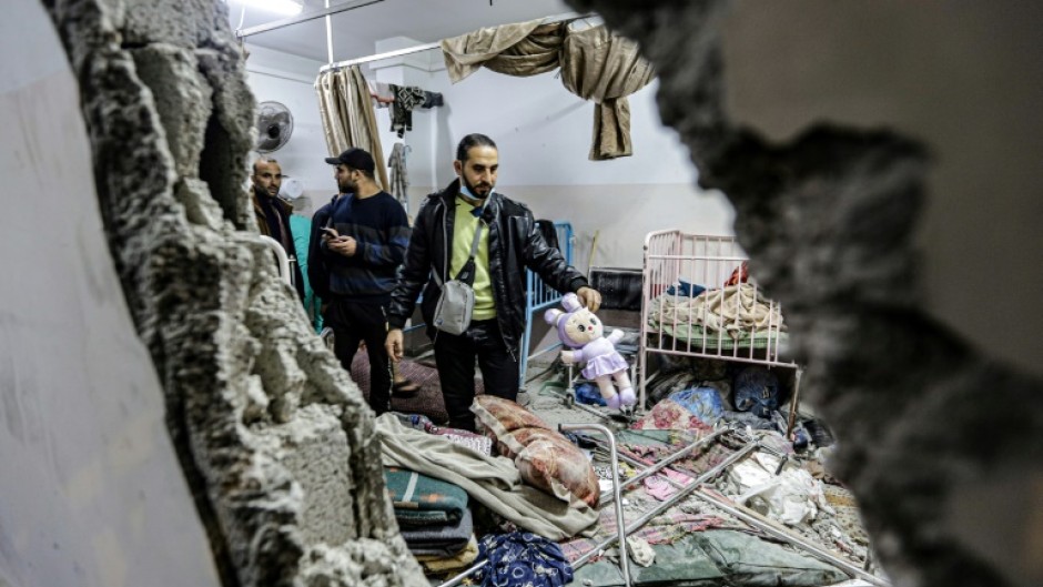 People inspect damage to a room following Israeli bombardment at Nasser hospital in Khan Yunis on December 17, 2023