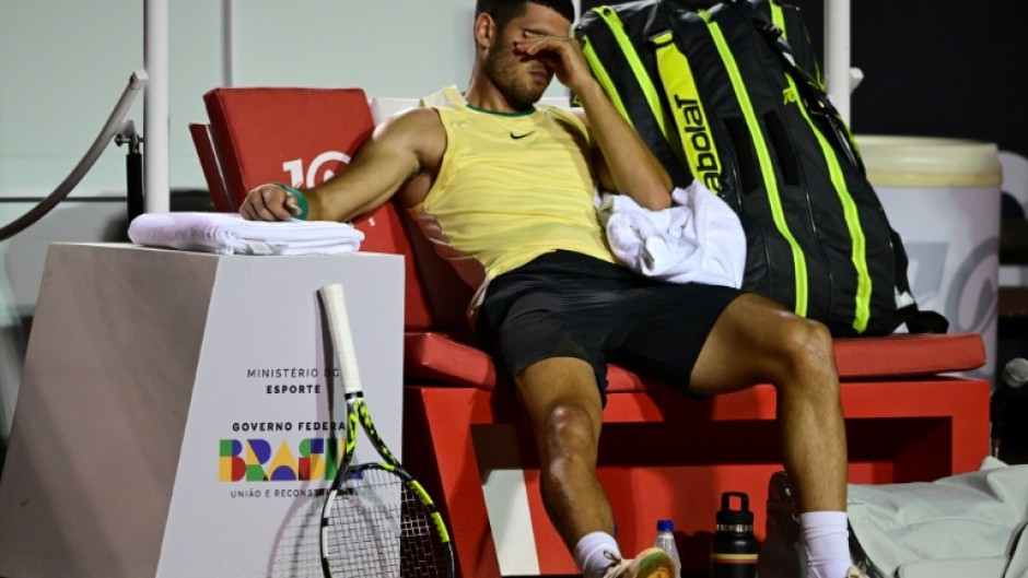 Spain's Carlos Alcaraz gestures after suffering an ankle injury in his ATP Rio Open first-round match against Thiago Monteiro